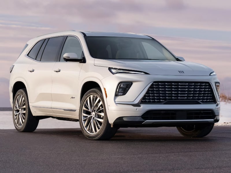 White SUV parked on a road, featuring a modern design with chrome accents and sleek headlights.