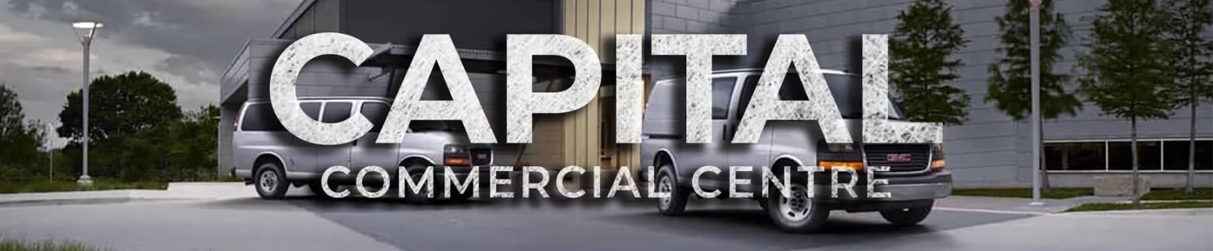 "Capital Commercial Centre sign with two parked vans in modern industrial setting."